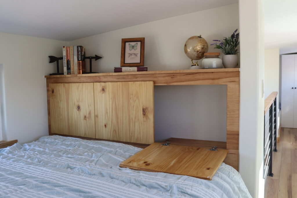 A multi-functional headboard in Frontier Tiny Homes' Felicity model offers a plethora of hidden storage!